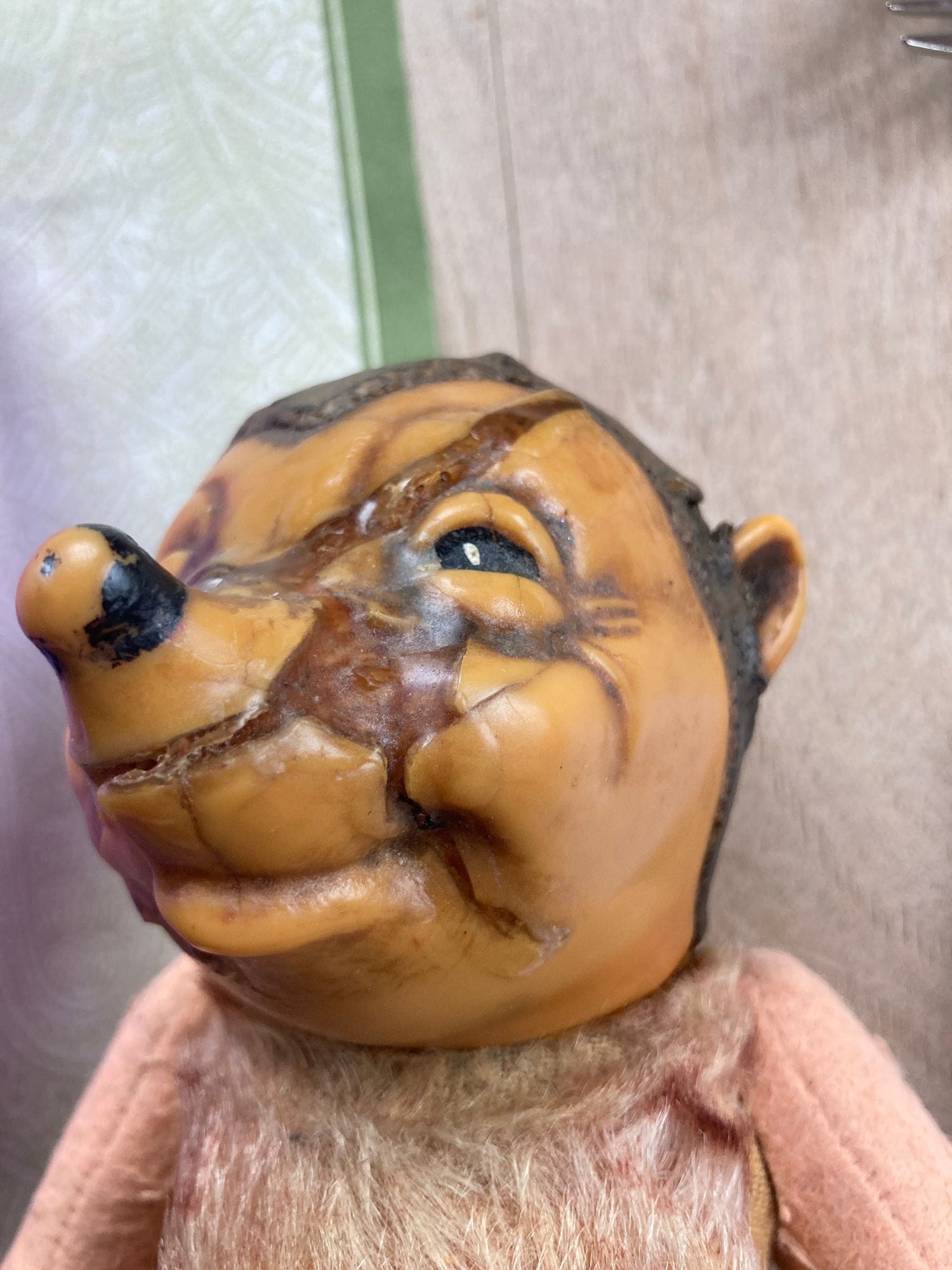 Mecki-Igelpuppe mit Rissen im Gesicht vor der Reparatur