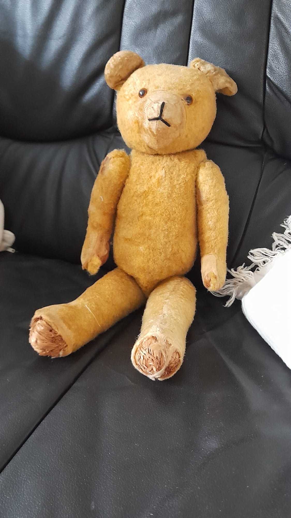 Vintage-Teddybär mit defekten Füßen vor der Reparatur